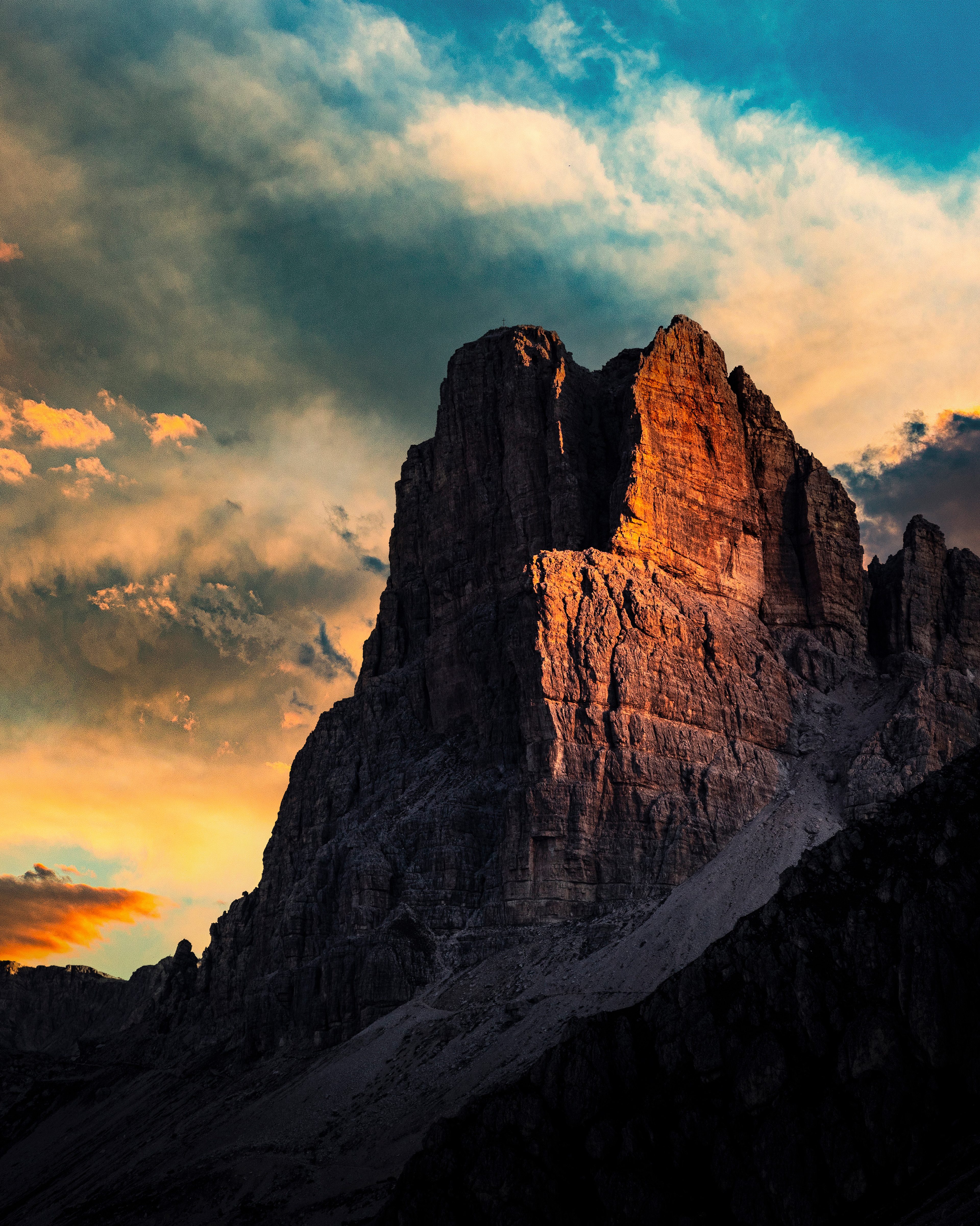La parete dell’Averau accesa dal tramonto tra nuvole e cielo azzurro, Dolomiti