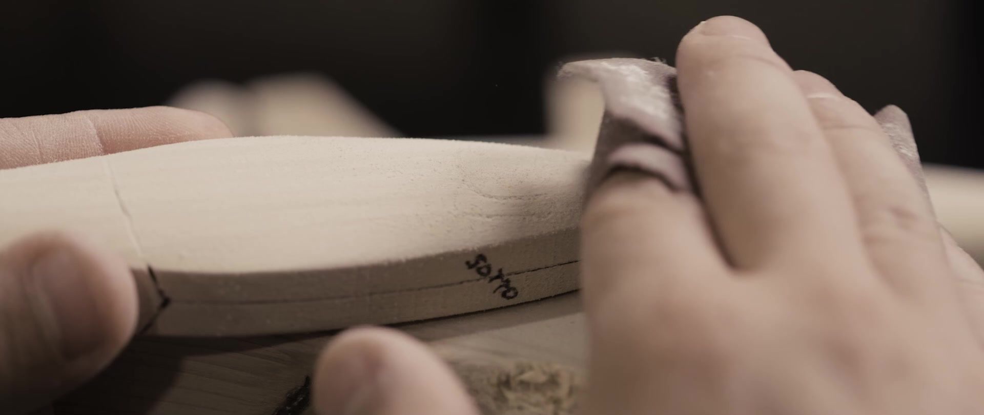 Le mani dell’artigiano che lavorano il corpo in legno di un’esca