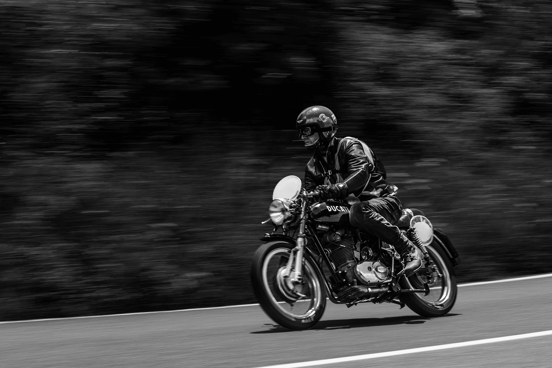 Moto d’epoca in strada in bianco e nero, effetto mosso