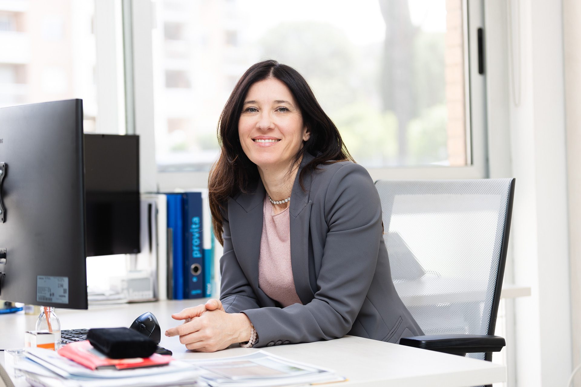Professionista seduta alla scrivania in un ufficio luminoso