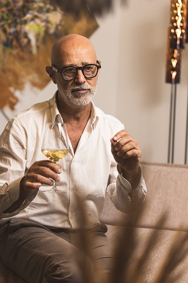 Uomo con la barba bianca e la camicia di lino che tiene un calice