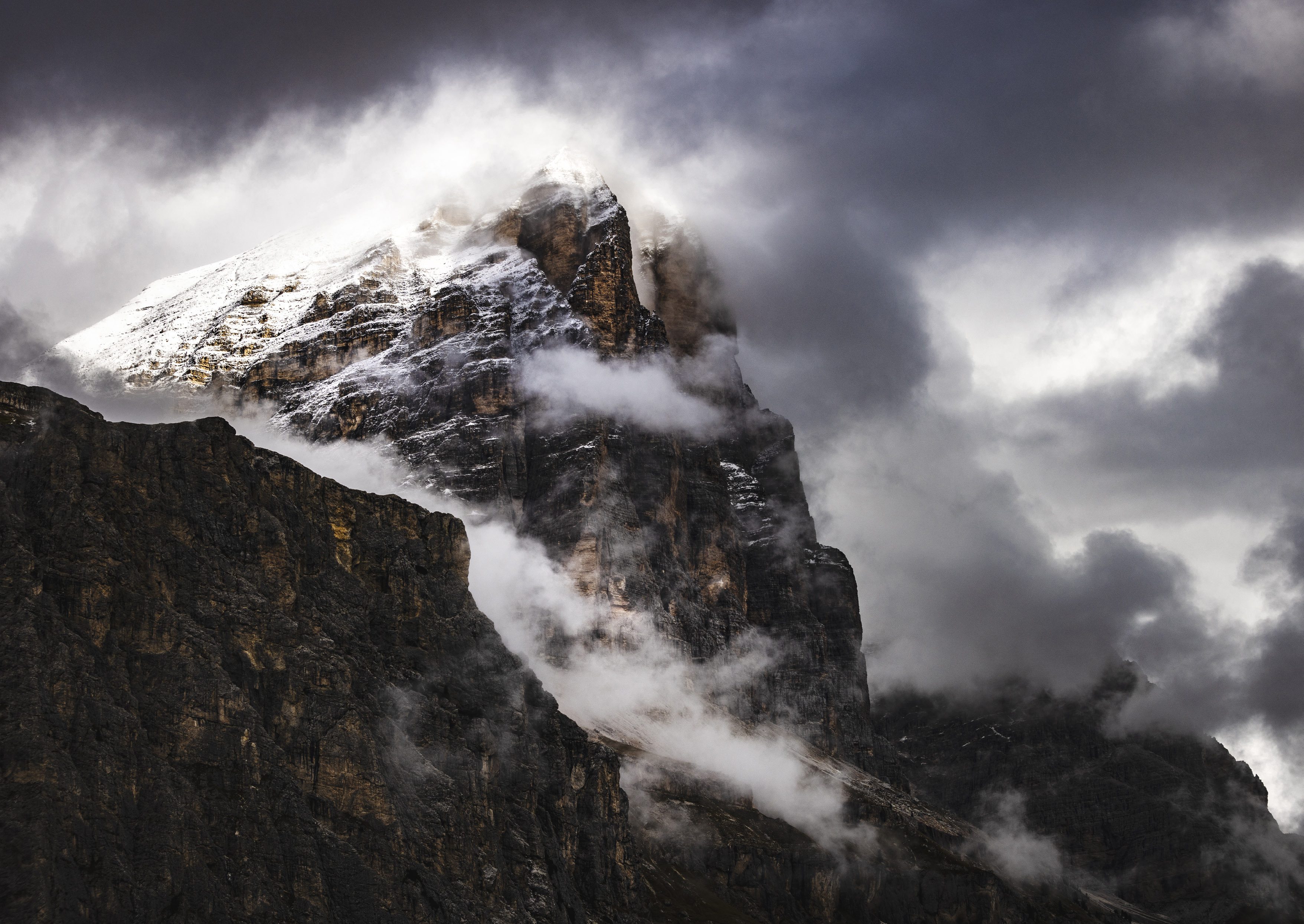 La Tofana di Rozes tra nuvole scure di tempesta, con la prima neve sulla cima